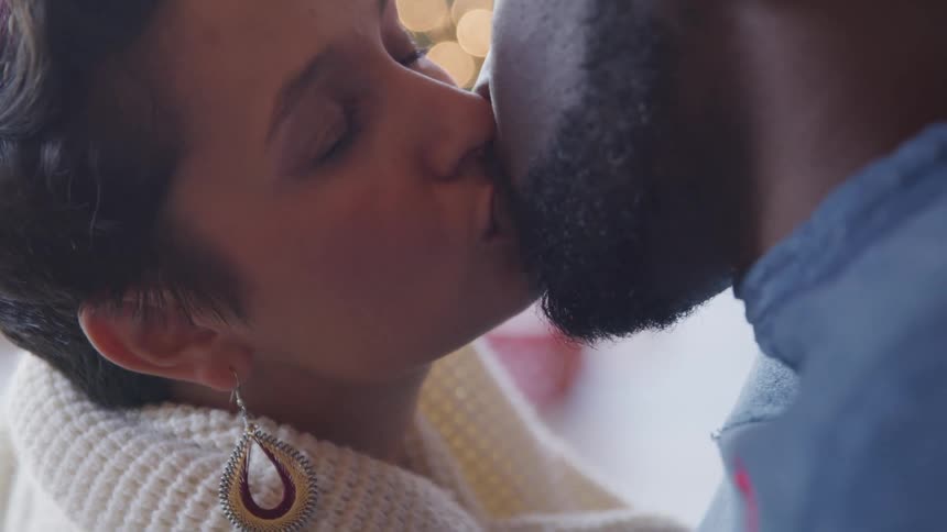 Man and woman kiss and smile at one another