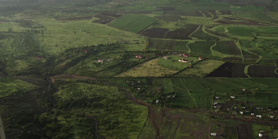 Aerial view of fields with houses below