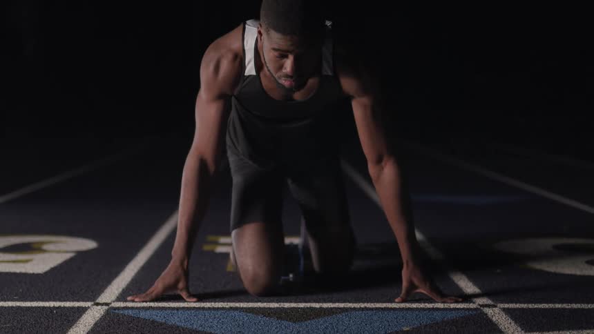 A man on a track gets ready to run