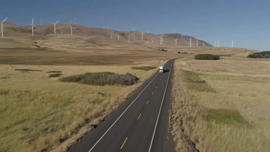 White truck driving through an empty road