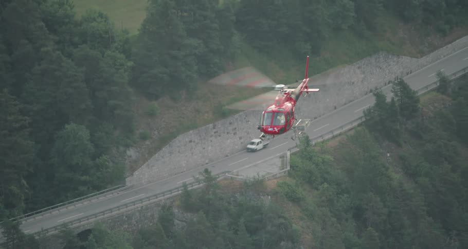 A helicopter over trees and a street