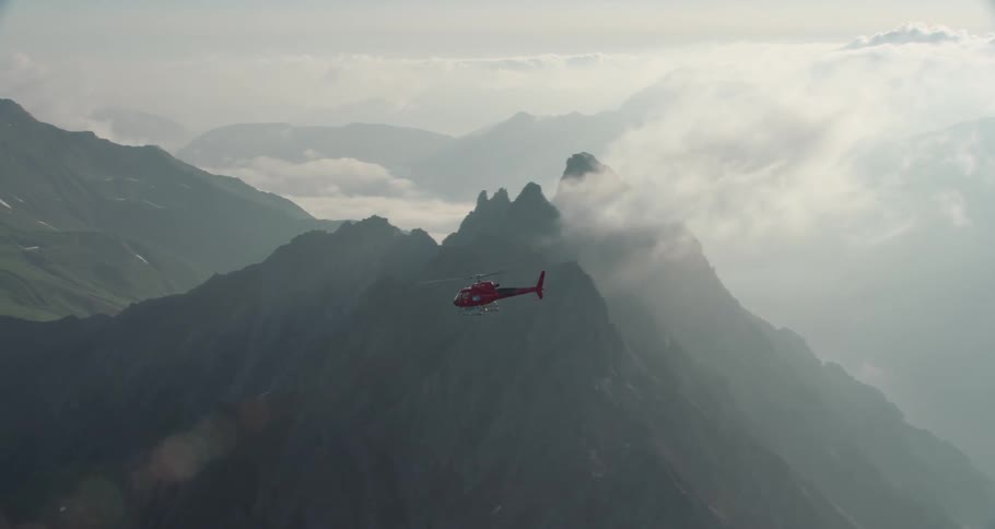 Helicopter flying above the clouds on the alps