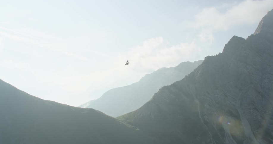 A helicopter flies over a mountain range