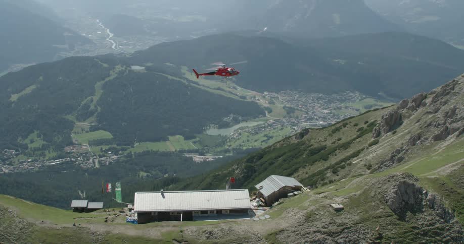 A helicopter flies close to a building