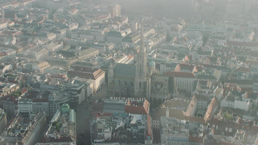An aerial view of a church surrounded by city buildings