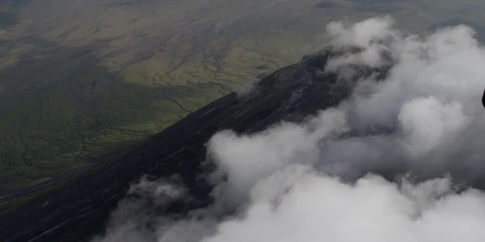 Fog rolls down a mountain