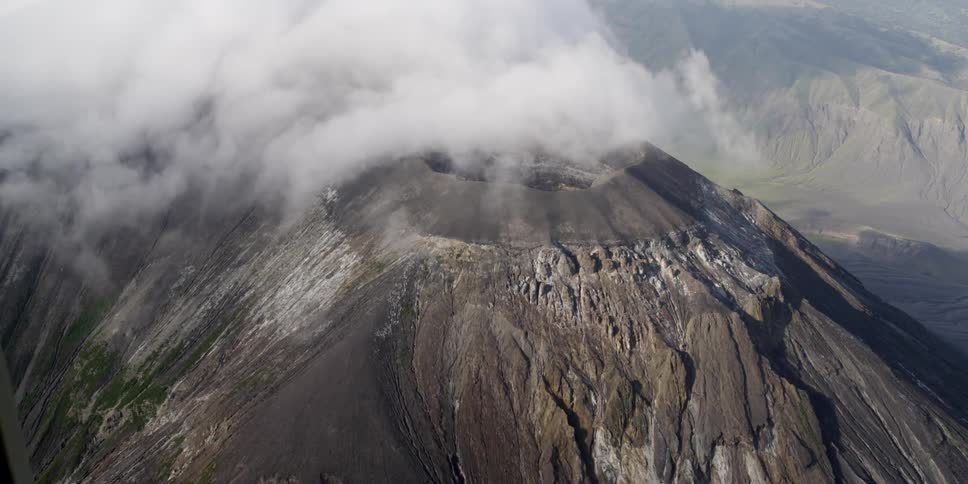 Clouds hover around a mountaintop