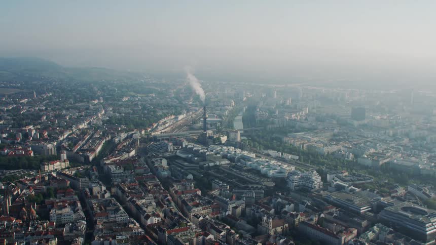 Fog obscures mountains on the horizon and parts of sprawling city and large park