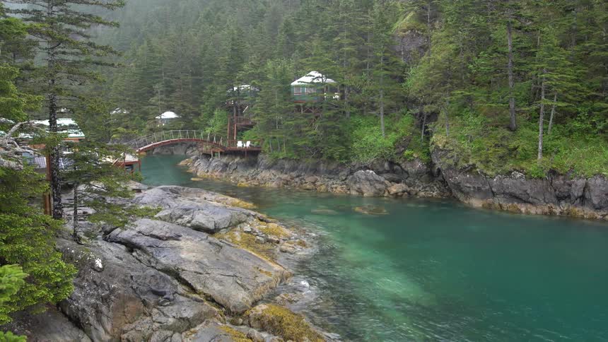 Buildings built on platforms dot area between forest and river