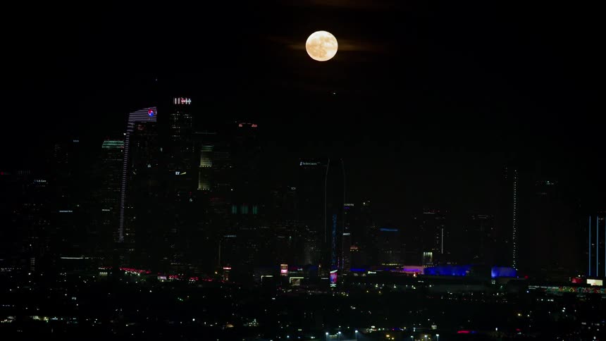 Full moon above city skyline at night
