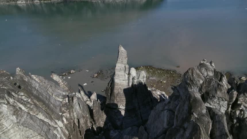 Jagged rocks above rugged beach at lake