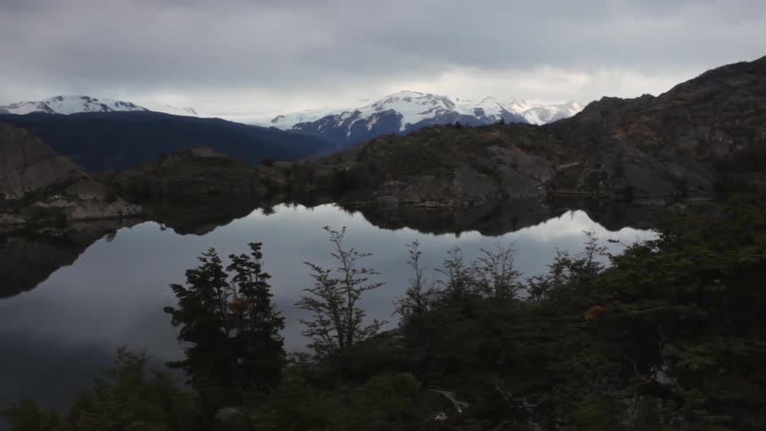 Clouds float over a calm mountain lake