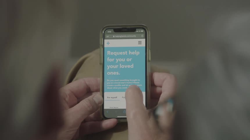 Two people navigate covid help related website on mobile phone