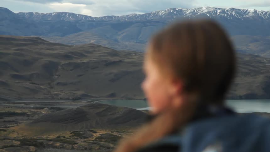 A woman stands overlooking a mountain range