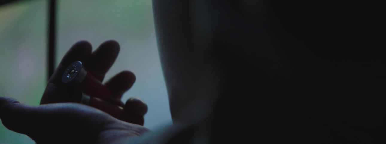 A man looks at bullets in his hand