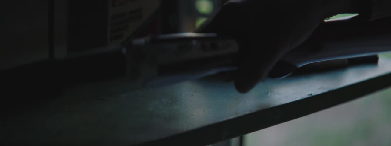 A man walks into a room and picks up a shotgun to check if it is loaded