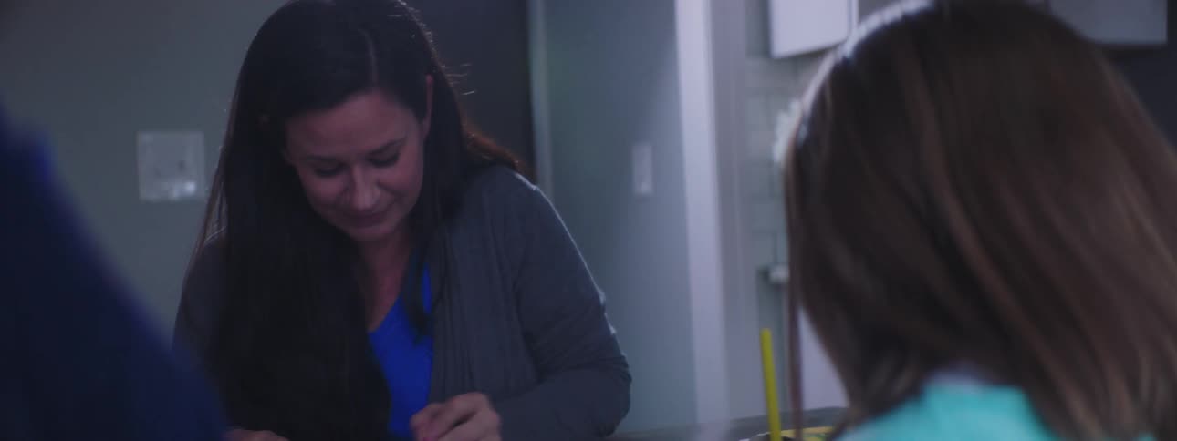 A woman and her children using colored pencils to color