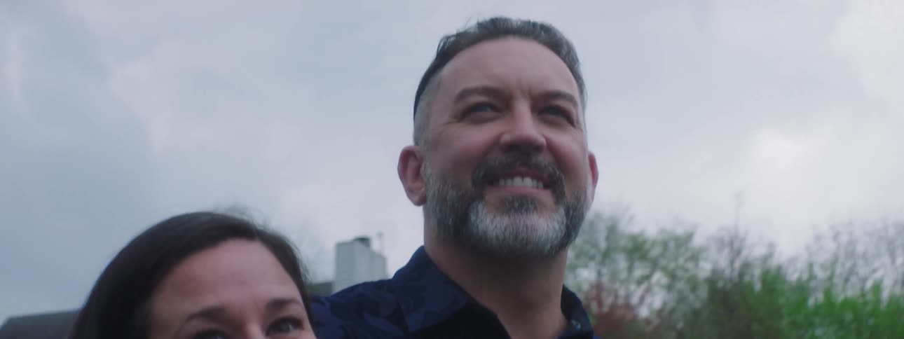 Bearded man walking on neighborhood streets with family
