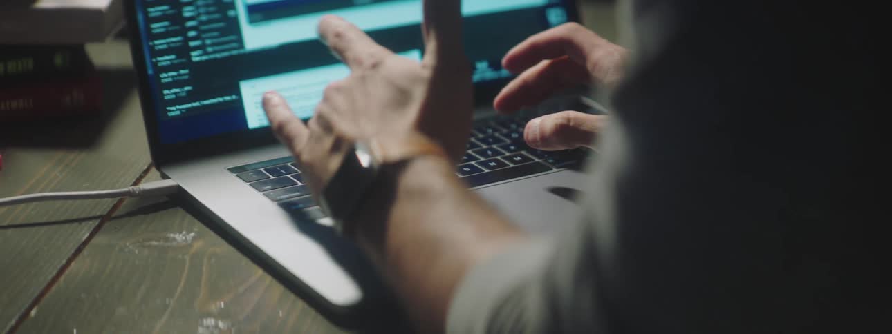 A man types on a laptop
