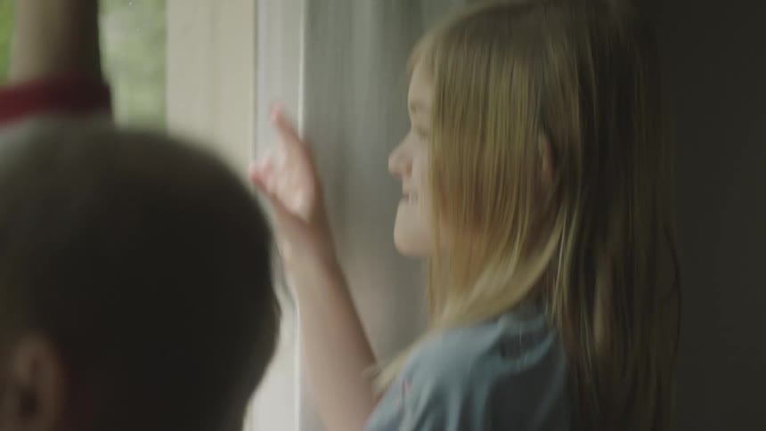 Three children jump and wave out window