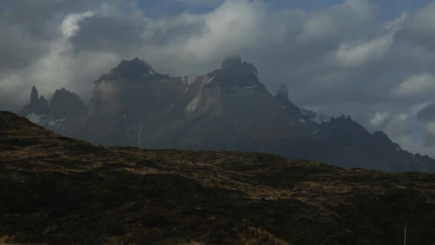 A large mountain range is covered in clouds on a cloudy day