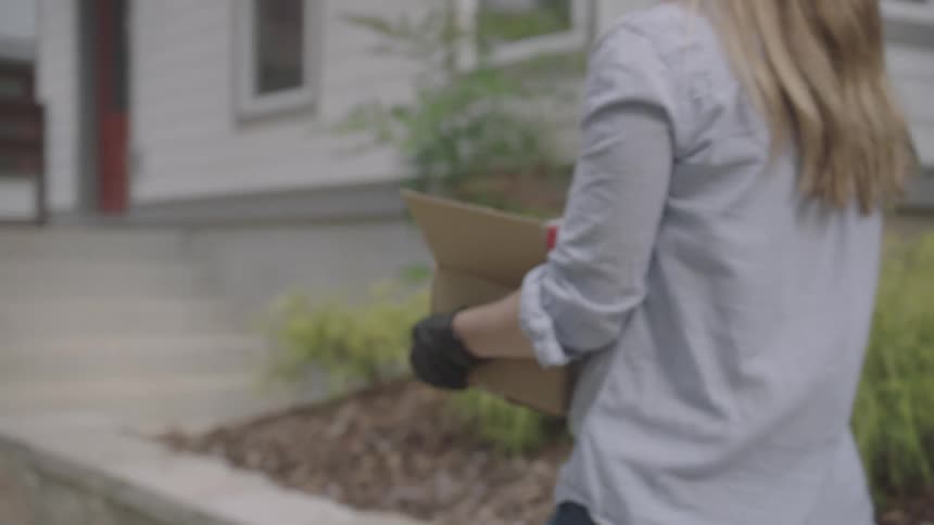 Woman delivers a cardboard box full of food during the lockdown due to the coronavirus