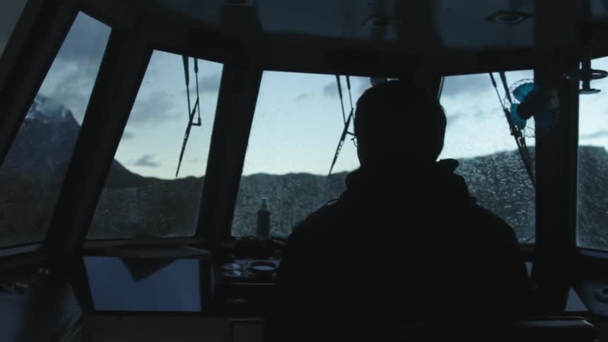 A man is a pilot bay steering on a cloudy day