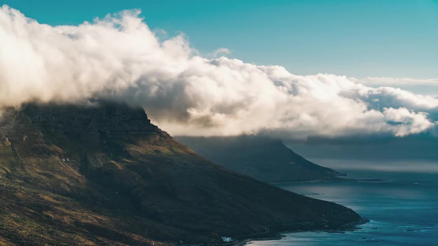 Clouds flowing over a mountain towards the coast