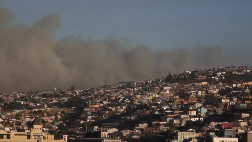 A dark cloud rolls over part of a city