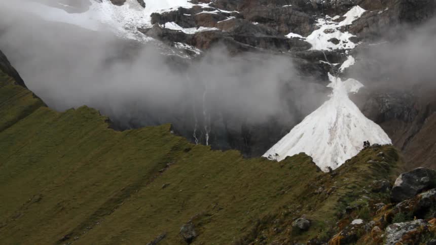 The top of a mountain has clouds on the surface