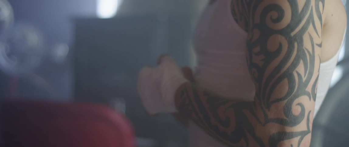 A man with taped up hands and a white vest on
