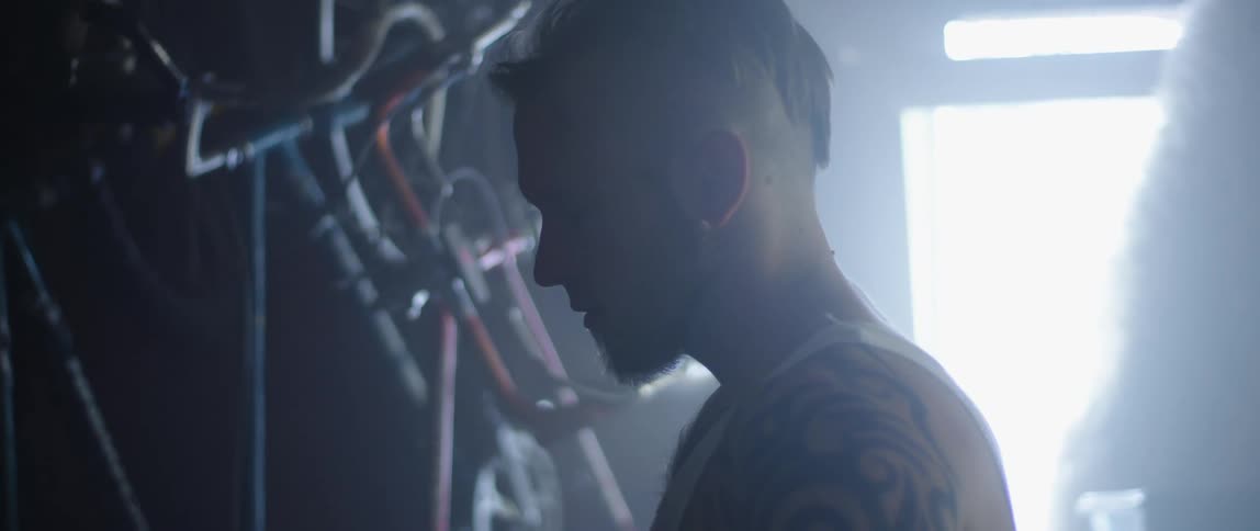 A man stands inside a garage and turns and looks behind him