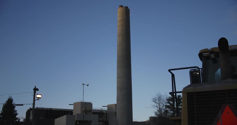 The tall chimney is on the side of the factory
