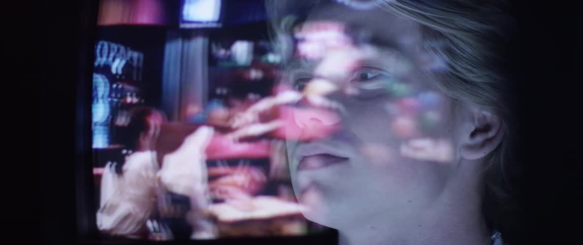 A teenager watches television on a projector