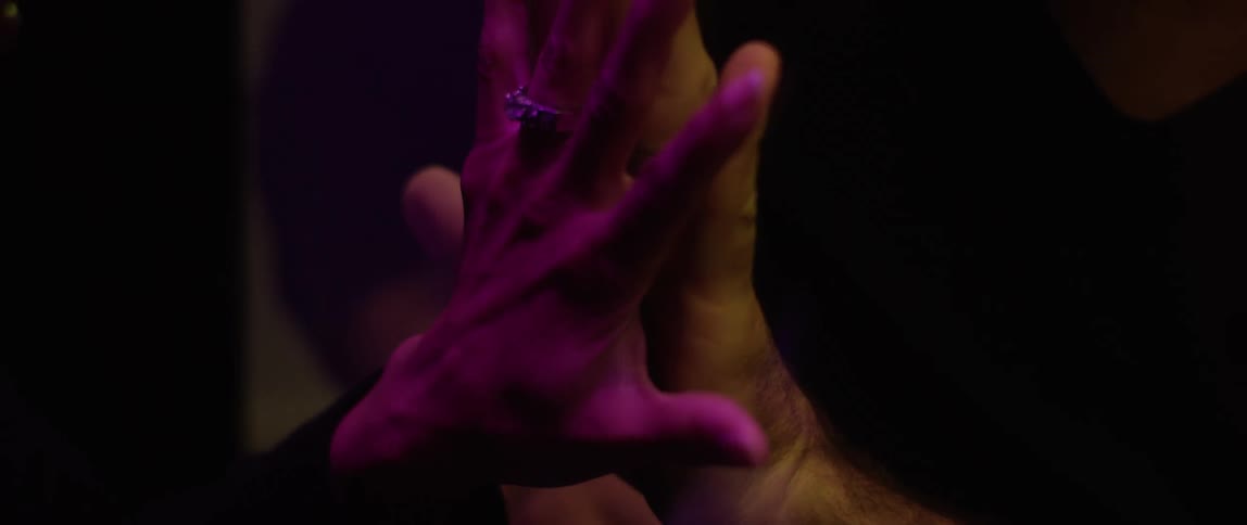 Female visitor meets a male prisoner through a glass partition that they put their hands on