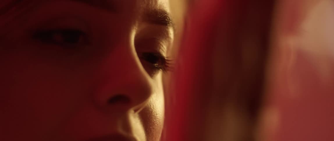 A woman looks ahead and runs her hand down in front of her face