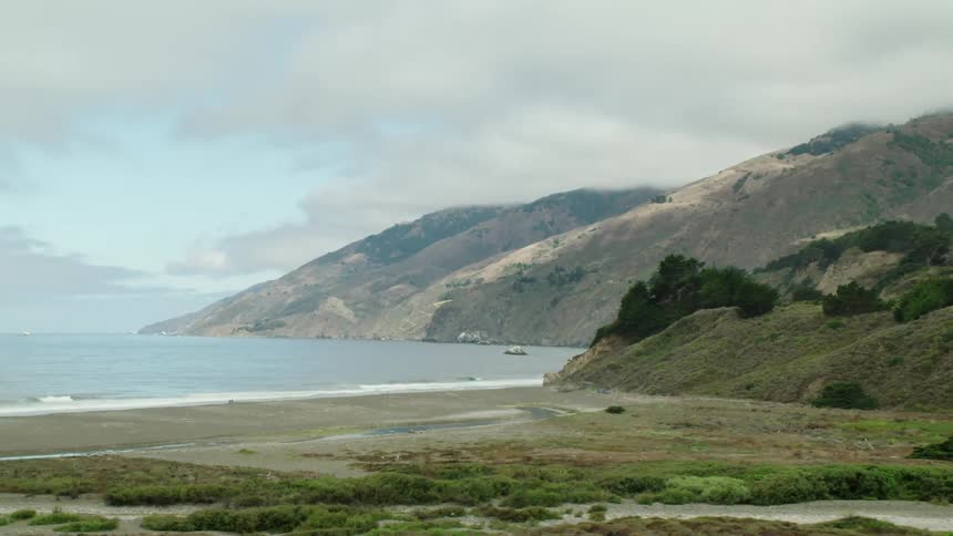 Oceanside mountains next to cove with beach