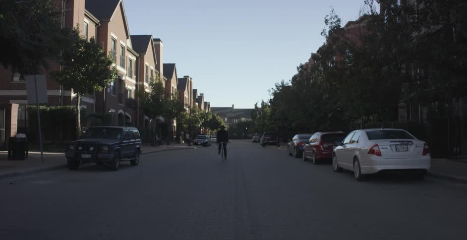 A man bicycles down a town street