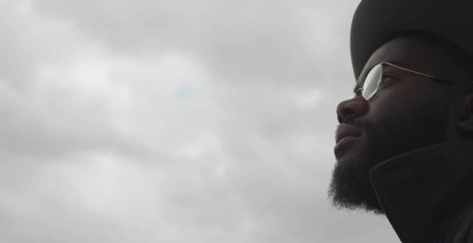 A man is standing outside on a cloudy day