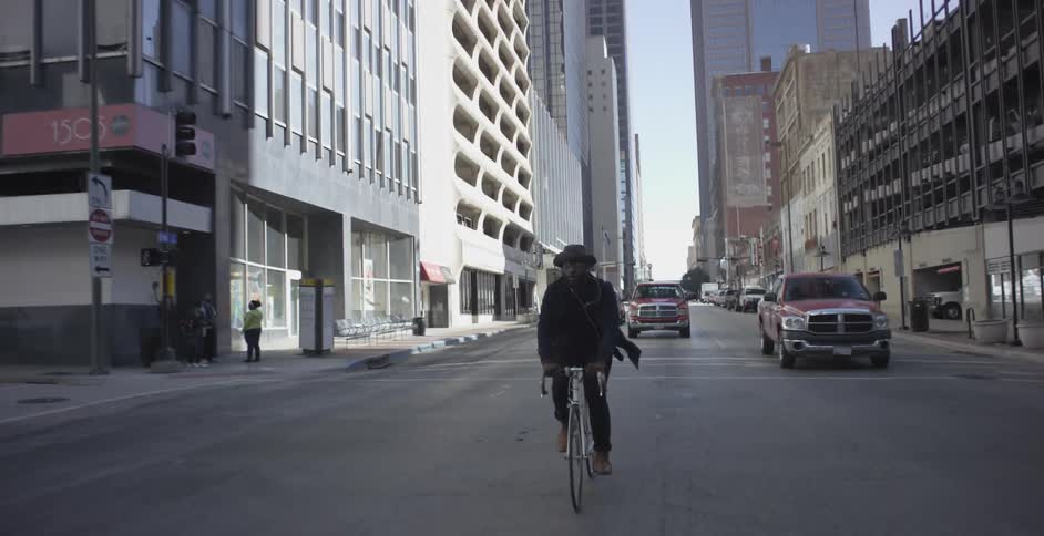 Man rides a bicycle down a city street