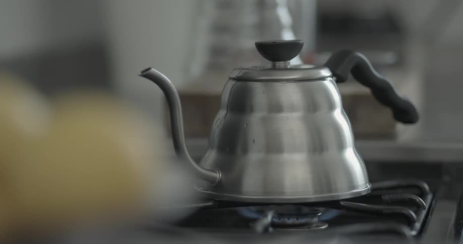 A tea kettle heats up on the stove