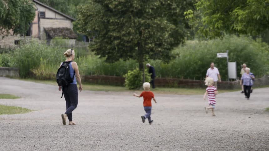 Elderly couples and a mother and her two young children walk along a trail