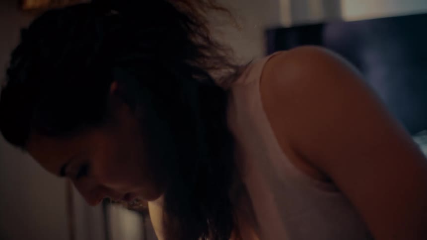 A woman is laying in bed and suddenly startled upward