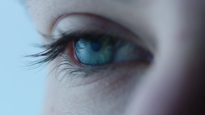 A blue eye with long eyelashes opens
