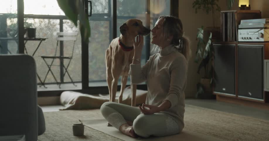 A woman with her dog doing yoga