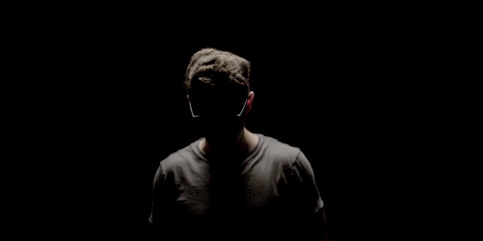 A man looks up in the dark room