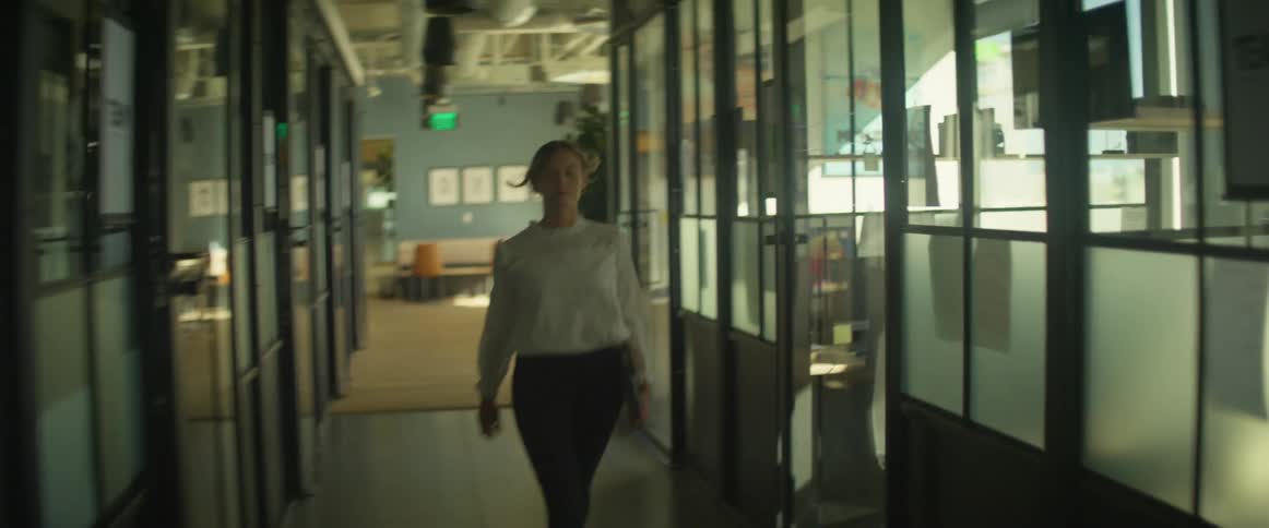 A female walking down a hallway office