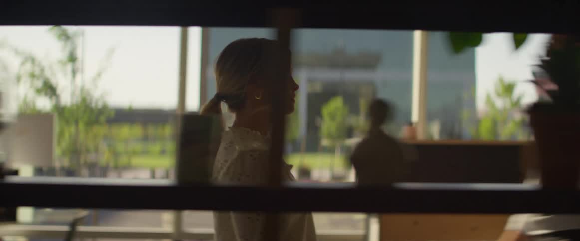 A woman walks down a corridor in an office building