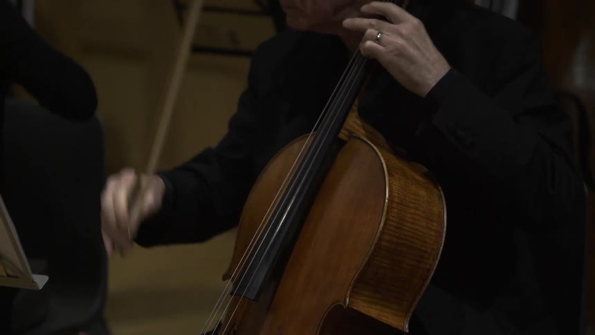 A person is playing a musical instrument in front of sheet music