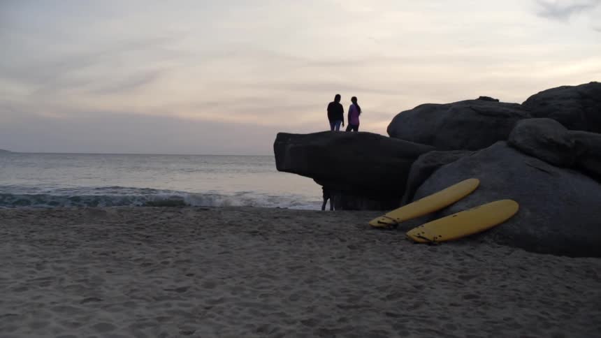 Three people on a beach with surf boards
